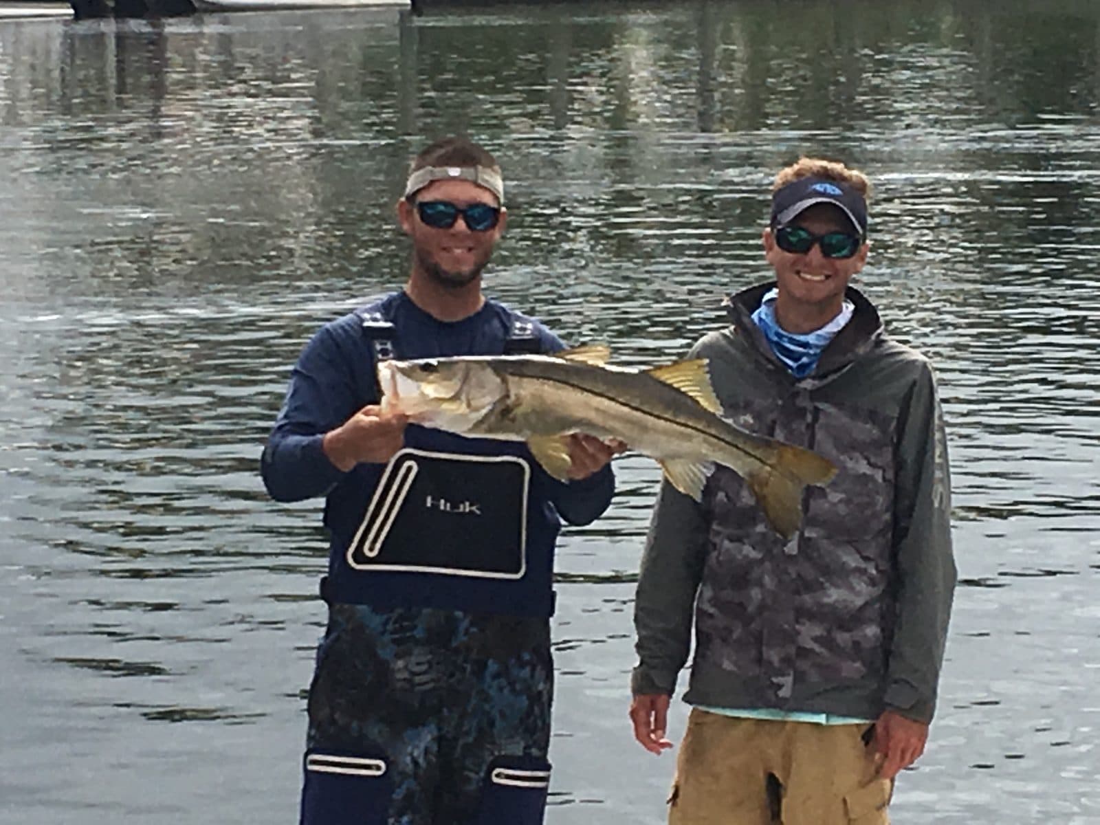 Two anglers holding snook