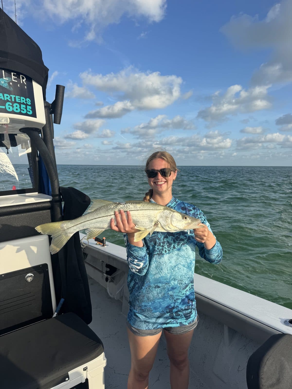 Angler holding a snook beside the console