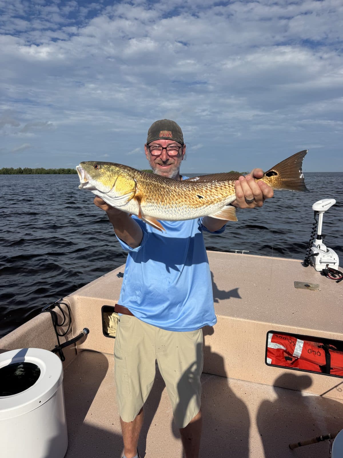 Angler holding a redfish on the casting deck