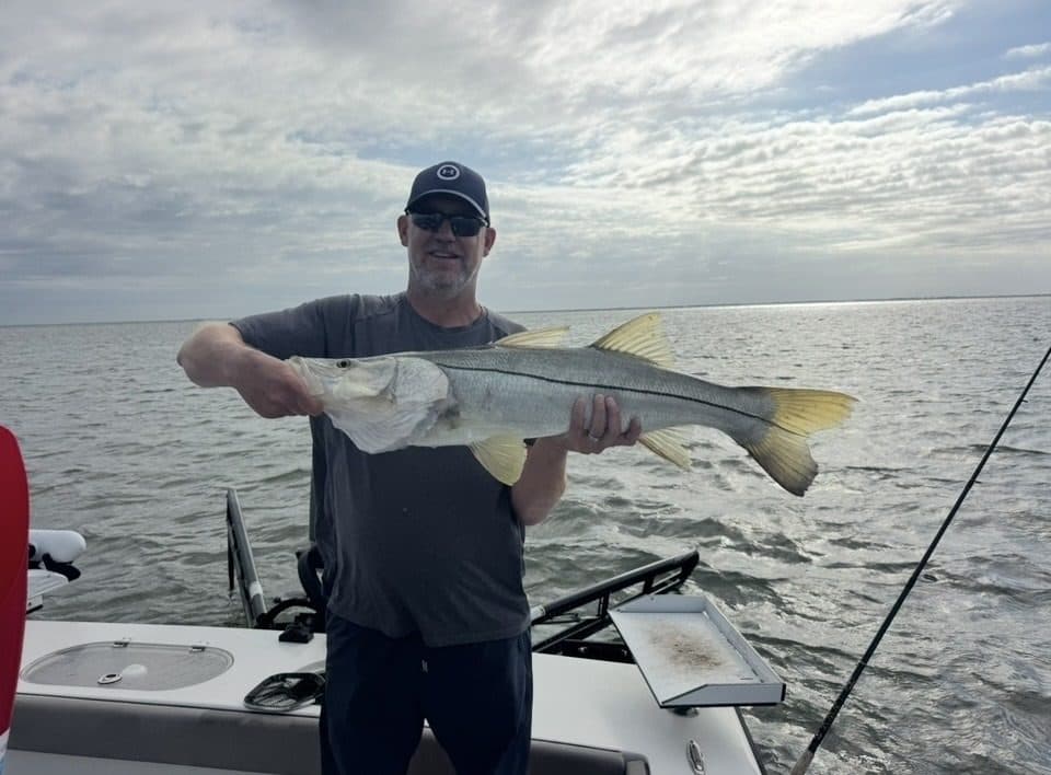 Angler holding a snook offshore of the islands